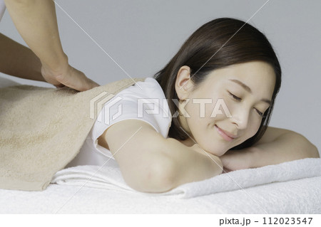 背中をマッサージしてもらう若い女性 112023547