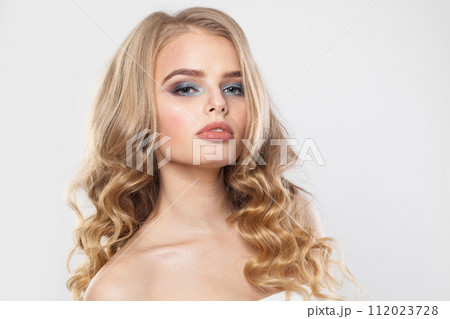 Pretty blonde model woman with perfect hairstyle, fresh clear skin and makeup on white background.  112023728