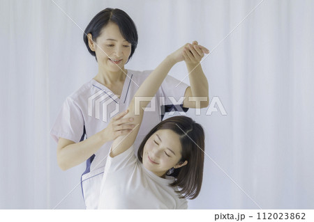 若い女性に施術をするミドルエイジの女性整体師 112023862