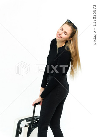 Pretty young woman pulling her heavy suitcase on white background. 112025973