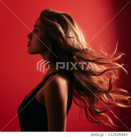 Profile of a beautiful young girl with long wavy hair. Silhouette of a slim pretty woman with stylish hair hairdressing. Side view of a girl with long hair looking forward on a red background. Profile of a beautiful young girl with long wavy hair. Silhouette of a slim pretty woman with stylish hair hairdressing. Side view of a girl with long hair looking forward on a red background. 112026862