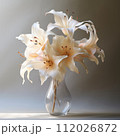 Beautiful transparent glass vase with standing on a gray background in the studio light. Transparent glass vase with big white flowers standing in the water. 112026872