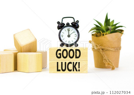 Good luck symbol. Concept words Good luck on beautiful wooden block. Beautiful white table white background. Black alarm clock. Business, motivational good luck concept. Copy space. 112027034