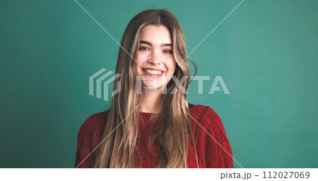 Happy woman with long blonde hair smiling in green studio Happy woman with long blonde hair smiling in green studio 112027069