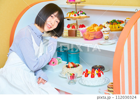 スイーツに囲まれる若い女性 スイーツに囲まれる若い女性 112030324