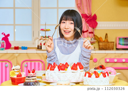 スイーツに囲まれる若い女性 スイーツに囲まれる若い女性 112030326