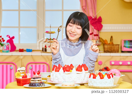 スイーツに囲まれる若い女性 スイーツに囲まれる若い女性 112030327