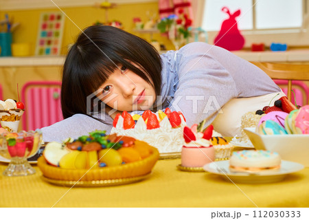 スイーツに囲まれる若い女性 スイーツに囲まれる若い女性 112030333