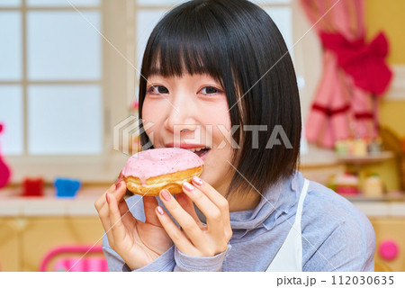 ドーナツを手にする若い女性 112030635