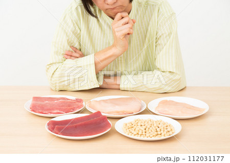 タンパク質の多い食材と悩むミドル女性 112031177