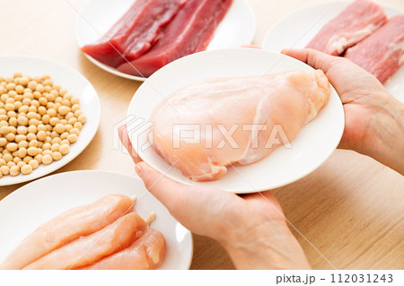 タンパク質の多い食材を持つミドル女性（鶏むね肉） 112031243