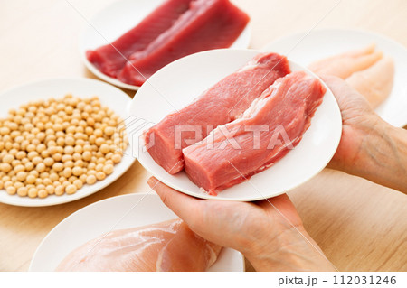 タンパク質の多い食材を持つミドル女性(豚ヒレ肉) タンパク質の多い食材を持つミドル女性(豚ヒレ肉) 112031246