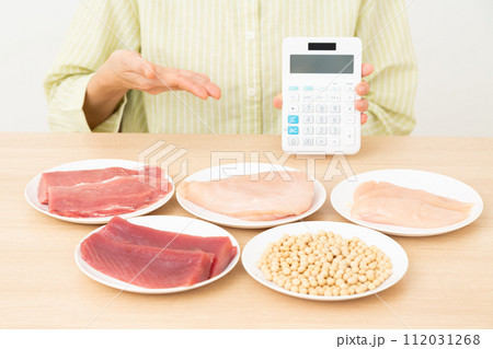 タンパク質の多い食材と電卓を持つミドル女性 112031268