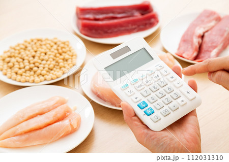 タンパク質の多い食材と電卓を持つミドル女性 112031310