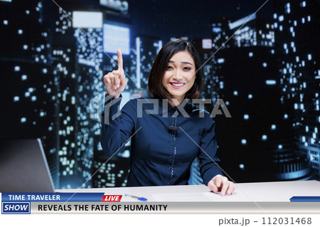 Newscaster talks about time traveler on television program, hosting night show to present secrets of humanity from future. Asian journalist addressing news about peoples fate. 112031468