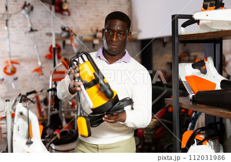 African-american man choosing drainline pump 112031986