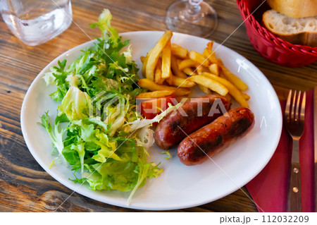 Sausages served with potatoes and salad Sausages served with potatoes and salad 112032209
