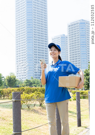 荷物を運ぶ宅配便の若い女性スタッフ 112032585