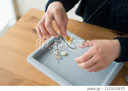 アクセサリーを袋詰めする女性の手 112032635