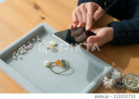 アクセサリーをスマホで撮影する女性 112032733