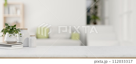 A presentation space on a white tabletop with a blurred background of a contemporary living room. A presentation space on a white tabletop with a blurred background of a contemporary living room. 112033317