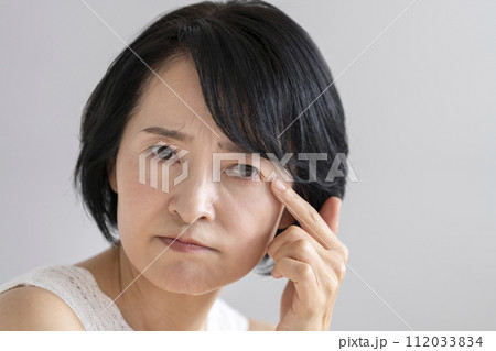 目元を気にする50代前半の女性　ビューティーイメージポートレート 112033834