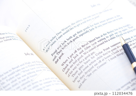 ページが開かれた英語の本で、のんびり読書を楽しんでいるイメージ 112034476