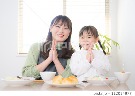 笑顔で美味しい食事や料理をいただきますする親子（ママと子供）の正面のイメージ 112034977