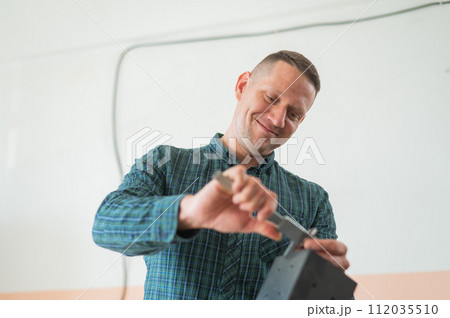 Carpenter measures a metal connector for wooden parts.  112035510