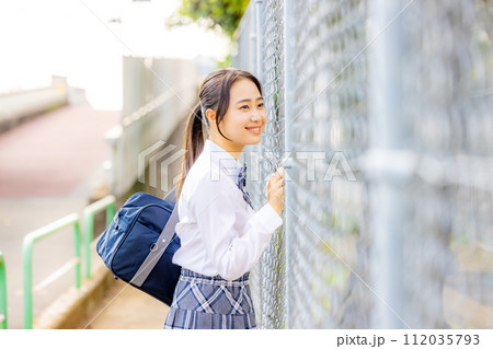 校舎の前に立つ制服を着た女子高生 112035793
