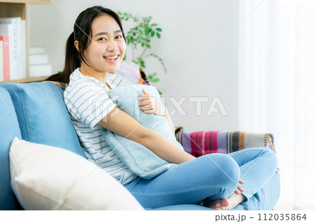 リビングでくつろぐ若い女性 リビングでくつろぐ若い女性 112035864