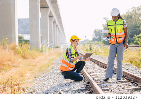 Engineer female railway tracks service team working on site survey check maintenance inspection train track for new construction and safety check Engineer female railway tracks service team working on site survey check maintenance inspection train track for new construction and safety check 112039327