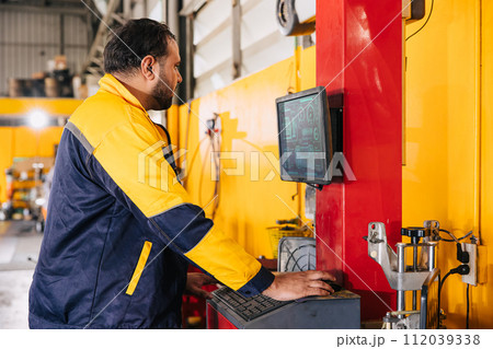 mechanic male worker using advance computer technology for tuning checking analysing car problem in auto salon service workshop mechanic male worker using advance computer technology for tuning checking analysing car problem in auto salon service workshop 112039338