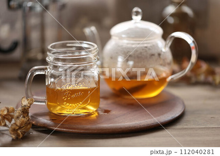 ガラスのティーポットに入れたルイボス茶とガラスのマグカップ 112040281