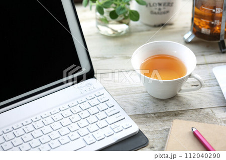 タブレット端末で仕事の合間にティーカップに注いだルイボスティー 112040290