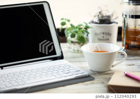 タブレット端末で仕事の合間にティーカップに注いだルイボスティー 112040293