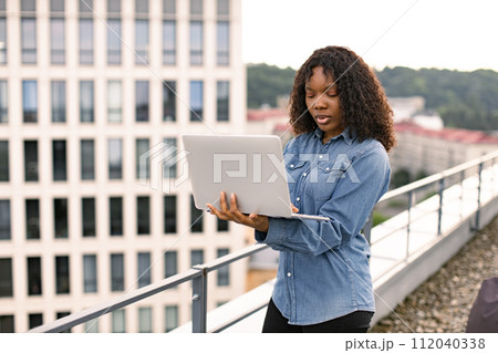 Business woman in casual denim shirt working on laptop. Business woman in casual denim shirt working on laptop. 112040338