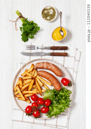 sausages with potato, lettuce, tomatoes, top view sausages with potato, lettuce, tomatoes, top view 112040339