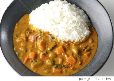 豚肉、かぼちゃ、人参などの野菜が沢山入ったカレーライスを白背景で俯瞰撮影 112042169