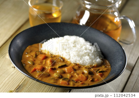 豚肉、かぼちゃ、人参などの野菜が沢山入ったカレーライスとお茶 112042534
