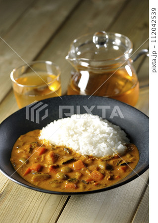 豚肉、かぼちゃ、人参などの野菜が沢山入ったカレーライスとお茶 豚肉、かぼちゃ、人参などの野菜が沢山入ったカレーライスとお茶 112042539