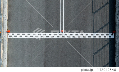 Aerial view abstract asphalt black Start and Finish grid line for race car in circuit texture background, Automobile and automotive background. 112042548