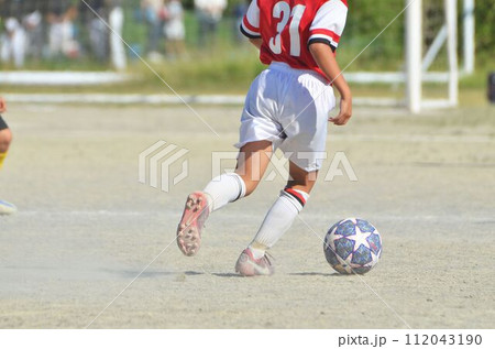 少年サッカーの試合（ドリブルする選手） 112043190