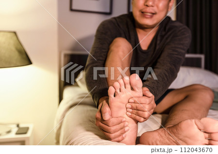 Asian middle aged man have severe cramp his calf muscle of leg,adult male people suffering from cramps of foot,problems of peripheral neuropathy,numbness or weakness in leg,beriberi in feet and toes 112043670