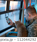 AI-generated content. A man with a cat and smartphone in public transport. High quality photo 112044292