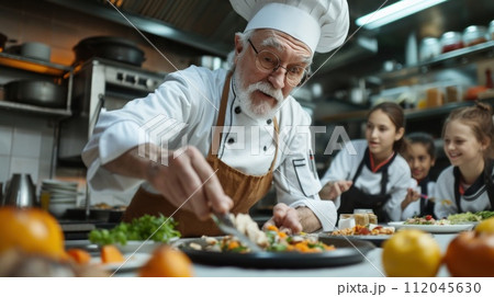 Master's skill: the chef instructs students in the art of cooking restaurant cuisine Master's skill: the chef instructs students in the art of cooking restaurant cuisine 112045630
