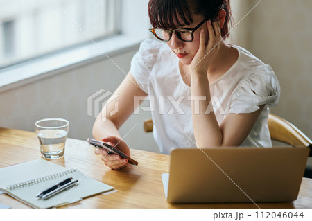 スマホで調べごとをする若い女性 112046044
