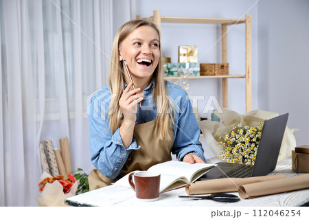 Beautiful girl florist with flowers and laptop. Beautiful girl florist with flowers and laptop. 112046254