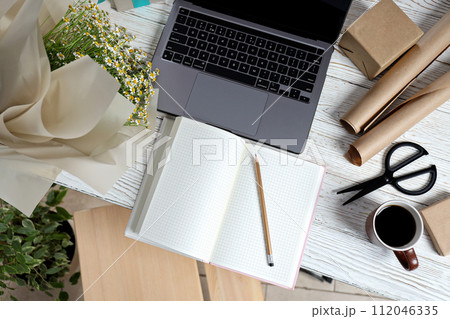 A florist's workplace, a bouquet, a laptop and a notebook. 112046335