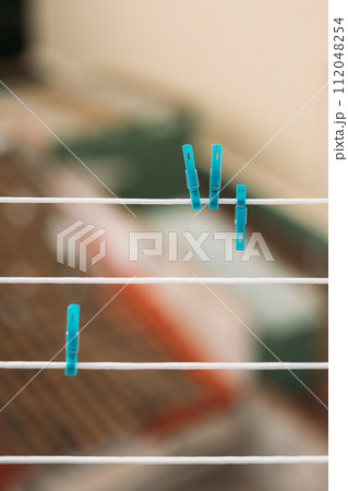 Blue Clothespins on white clothesline with blurred background 112048254